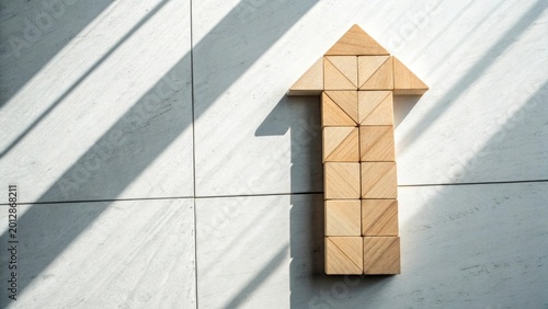 Wooden puzzle pieces forming upward arrow on gray surface