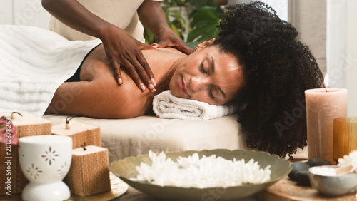 Relaxed Woman Receiving Shoulder Massage At Spa With Candles And Aromatherapy Bowl