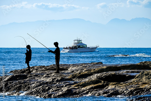磯で釣りをする人物シルエット｜趣味や休日イメージに使える海景写真