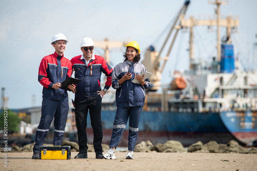 Fototapeta premium Port engineering team collaborating near cargo vessel and industrial shipping terminal