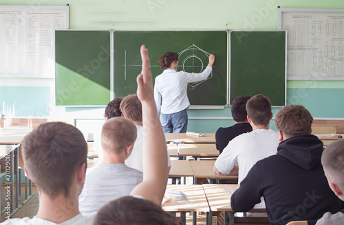 A view from behind a student answering a question during a university lecture.