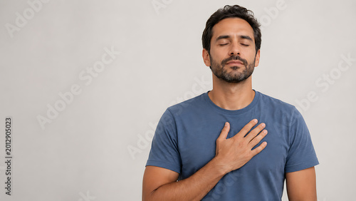 Peaceful man holding hand on chest feeling gratitude and relief