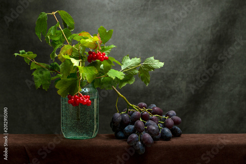 Schilderij op canvas Still life with ripe grapes and red viburnum branches