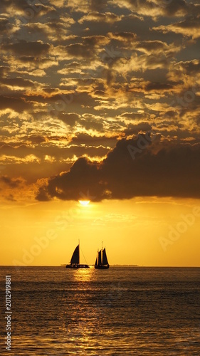 Two Sailboats Silhouetted Against Golden Sunset Sky In Key West Florida USA Seascape