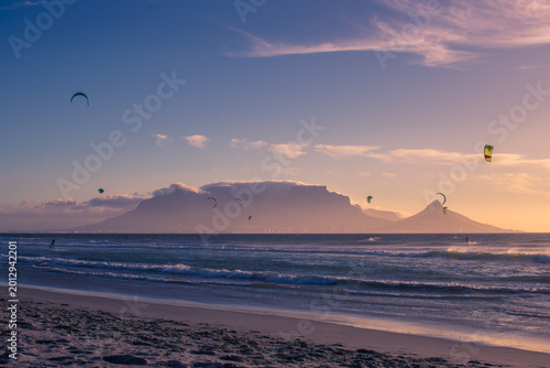 Φωτογραφία Table Mountain and Lion's Head Silhouetted at Sunset with Kitesurfers, Bloubergs