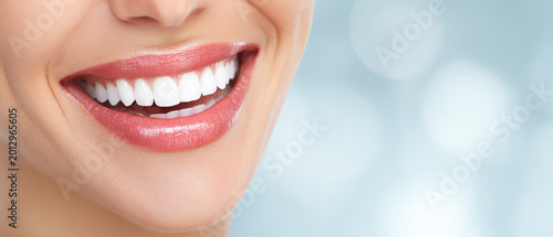 Close up of smiling mouth with white teeth and glossy lips on soft background. Healthy dental aesthetics with natural smile and clean bright teeth in beauty concept