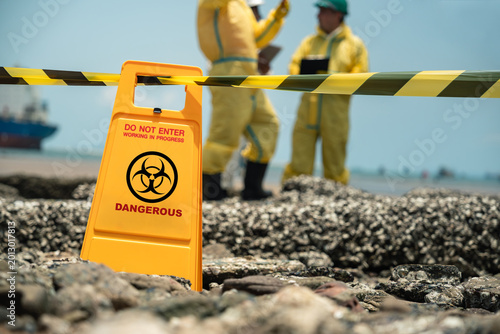 Pollution Warning Sign Behind Safety Barrier Tape During Coastal Environmental Wastewater Inspection In Industrial Contamination Area