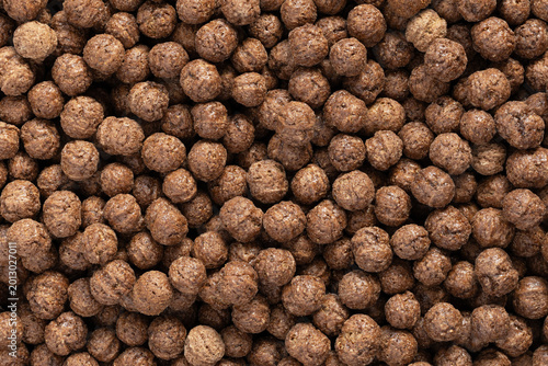 Chocolate breakfast cereal balls texture background. Close-up of cocoa puffed grain snacks
