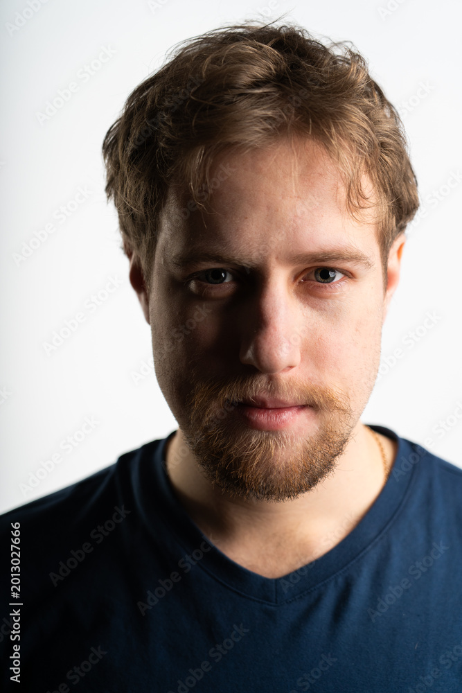Fototapeta premium Serious young bearded man portrait with dramatic shadow