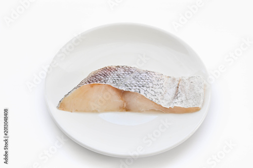 Foto 白背景のお皿にのった生の真鱈の切り身