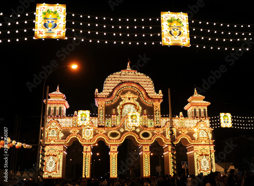 Portada de la Feria de Abril de Sevilla por la noche iluminada por miles de bombillas. Feria de Sevilla 2026, Andalucía, España. Alumbrado de la feria. 