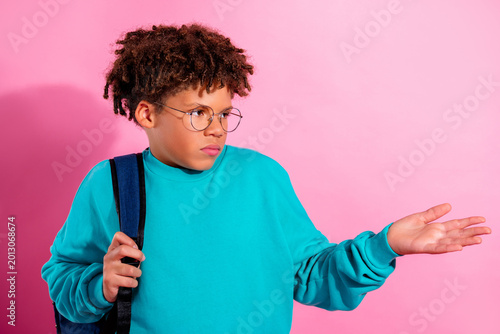 Tableau sur toile Teen boy shrugging with backpack and glasses against pink background showing con