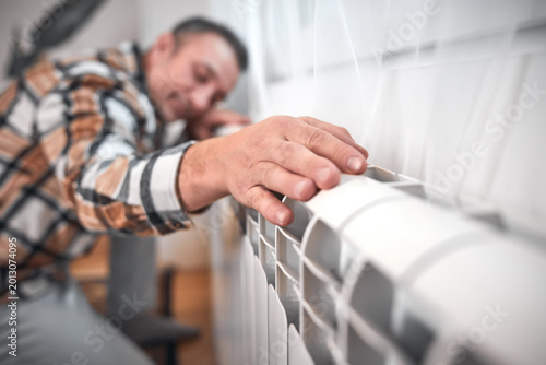 Fotografía Man heating on a chilly winter day, energy and gas crisis, cold room, heating problems