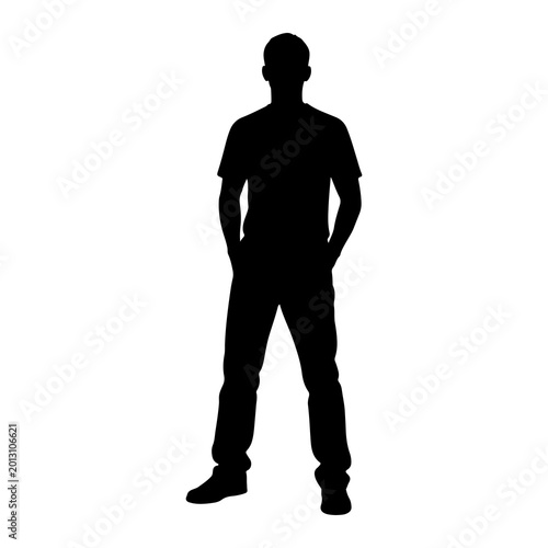 Silhouette of a casual young man standing with hands in his pockets