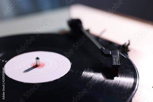 Modern turntable with vinyl record on white table , closeup