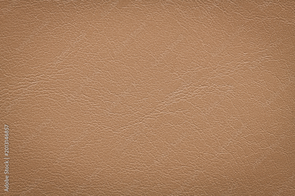 Fototapeta premium Macro shot of a high-quality light brown leather material featuring a fine grained texture and subtle sheen suitable for professional upholstery or fashion design