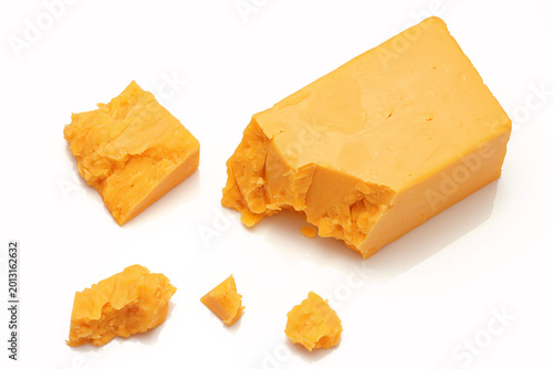 Broken Chunks of Orange Cheddar Cheese on white background