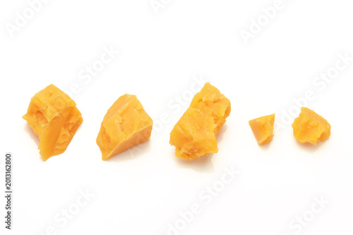 Fotografie Broken Chunks of Orange Cheddar Cheese on white background