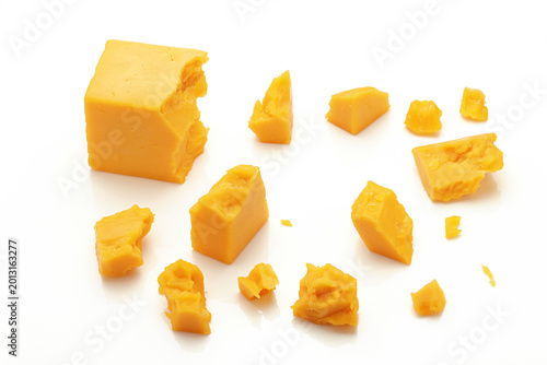 Fotografie Broken Chunks of Orange Cheddar Cheese on white background