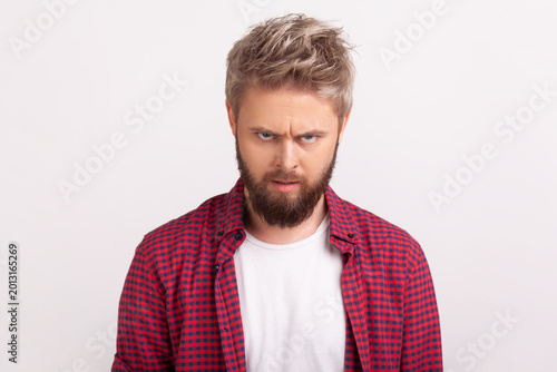 Confused bearded man looking directly at camera with slightly furrowed brows uncertain expression posing isolated over white background