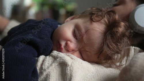 Bild auf Leinwand Sleeping baby resting with eyes closed on mother’s chest, intimate close up port