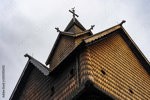 Pagan dragon heads and Christian crosses on the roof of the stave church in Norway. Authentic traditional Norwegian stabbur (raised wooden storehouse) in the rural landscape of Rjukan, Telemark.