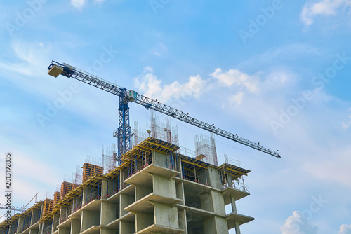 Fotografija the tower crane works against the background of the monolithic frame of the hous
