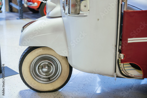 Canvas-taulu Detailed view of front section of vintage white three-wheeled vehicle, showcasing classic design elements