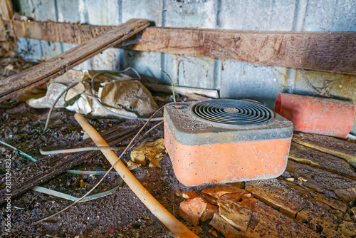 Quadro em tela Old dusty electric heater in abandoned rustic shed with debris and dirt