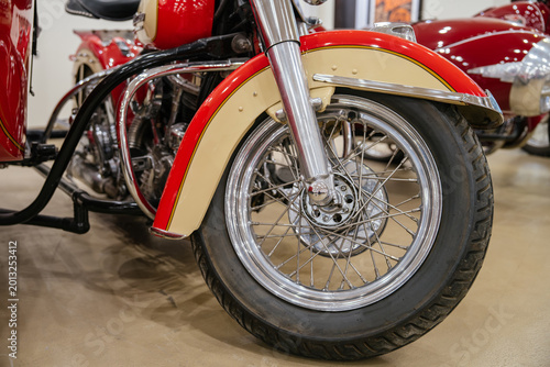 Canvas Print Detailed low-angle view captures front wheel and two-tone cream and red fender of classic motorcycle