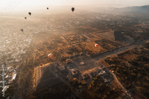 Aerial view of hot air balloons over Teotihuacan pyramids at sunrise in Mexico showcasing ancient architecture and landscape