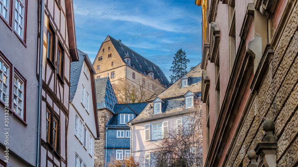 Obraz premium Marburg castle towering above historic half-timbered houses