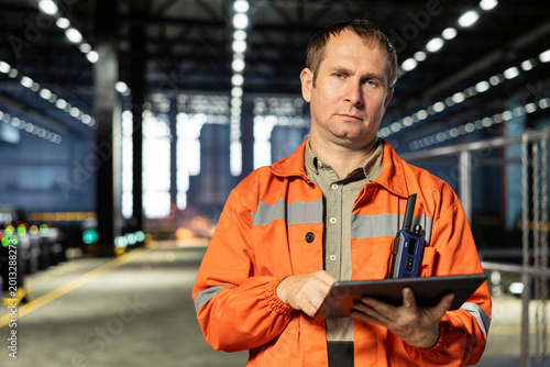 Tableau sur toile Portrait of operator with tablet handling metal fabrication in industry plant, showcasing manpower and reliance on machinery and technology within the industrial environment