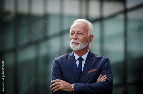Businessman with arms crossed outside