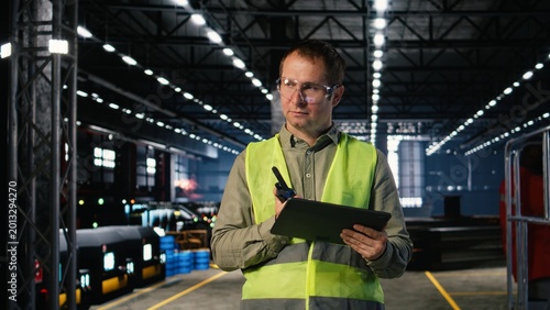 Photos Employee speaking through walkie talkie radio to oversee machinery operation, demonstrating manpower and the professional responsibility in manufacturing and production