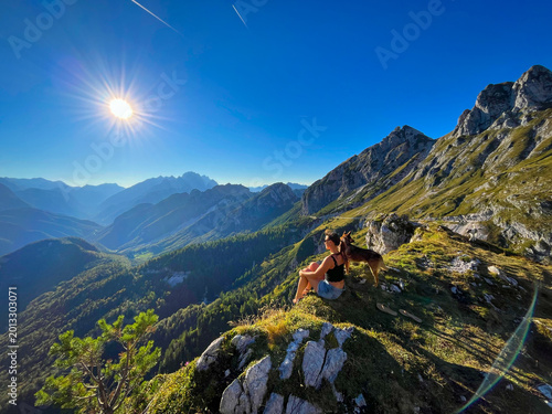 Φωτογραφία Woman and her mixed breed dog rest at a scenic viewpoint high above the valley at Mangart Pass