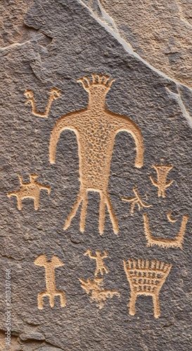 Ancient Petroglyph Figures Carved Into Weathered Desert Rock Surface