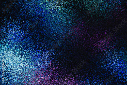 Dark frosted glass texture illuminated by vibrant neon blue and purple lights