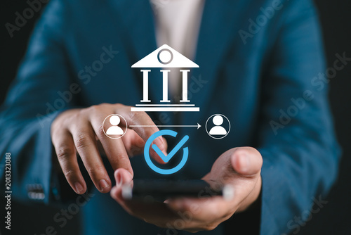 Tableau sur toile Businessman using smartphone for secure financial transactions and mobile banking, representing safe money transfer, verified payments, and digital banking solutions