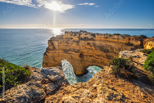 View of Praia da Marinha beach in Algarve, Portugal, with ocean cliffs, sea stacks and natural arch formations.