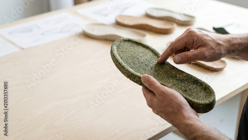Hands Inspecting Biodegradable Sneaker Sole Made From Recycled Cork and Algae Materials
