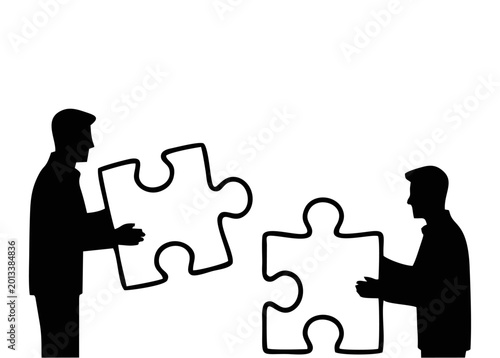 Silhouette of business people assembling large puzzle pieces together
