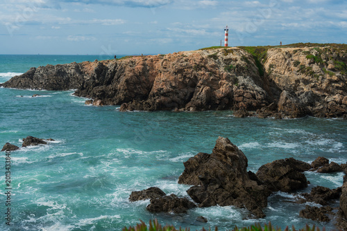 Tableau sur toile Dramatic Coastal Landscape with Lighthouse on Cliff Overlooking Turquoise Ocean Waves and Rocks