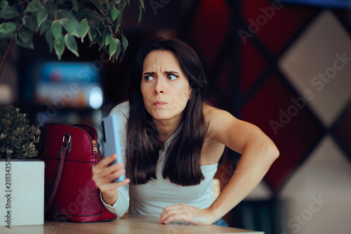 Billede på lærred Secretive Undercover Woman Filming Restaurant Scene with Smartphone