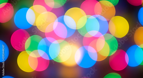 Vibrant multicolored bokeh light background texture.