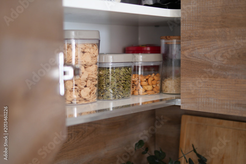 Fotografie Organized kitchen shelves with containers of food items