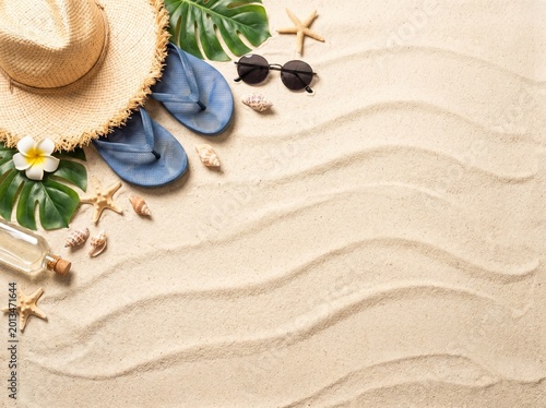 Flat lay of tropical summer beach accessories on sand background
