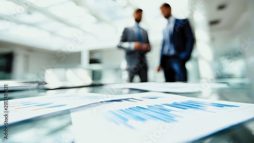 Business professionals reviewing financial reports and data on a table in a modern office environment