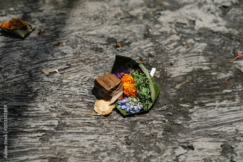 Traditional Balinese Canang Sari Offering Baskets with Colorful Flowers on Ground