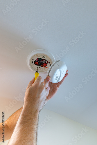 Valokuva Electrician using a screwdriver to install a hardwired smoke and carbon monoxide